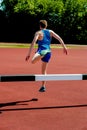 Athlete jumping over the hurdle