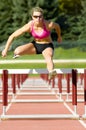 Athlete Jumping Over Hurdles on a Track Royalty Free Stock Photo