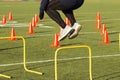 Athlete jumping over yellow hurdles