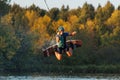 An athlete jumps over the water. Wakeboard park at sunset. Rider performs a trick on the board