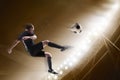 Athlete kicking soccer ball in stadium Royalty Free Stock Photo