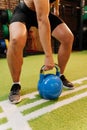 Athlete lifting blue kettlebell during functional workout in modern gym Royalty Free Stock Photo