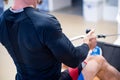 Athlete makes low cable pulley row seated in gym. Close back view