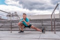 Athlete man doing leg stretching before morning workout. In the summer in the city, preparation for a run, sportswear Royalty Free Stock Photo