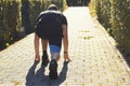 Athlete man in running crouch start pose in sunlight during sunset Royalty Free Stock Photo