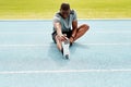 Athlete man, sitting and track for stretching legs to start training, exercise or running for fitness outdoor. African Royalty Free Stock Photo