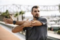 Athlete man stretching before running in the street. Active and sport young male in sportswear warming up for training Royalty Free Stock Photo