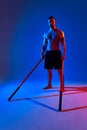 athlete men silhouette with stick training karate using sports tool in studio on colorfull lights background