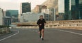 Athlete, morning and running in city street, road and bridge for fitness, workout and marathon training. Man, person or