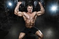 Athlete muscular bodybuilder in the gym training with dumbbells