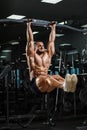 Athlete muscular fitness male model pulling up on horizontal bar