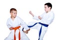 An athlete with an orange belt makes protective reception from kick kicking
