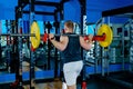 Athlete performs barbell squats in the gym