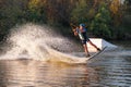 An athlete performs a trick on the water. Park at sunset. Wakeboard rider Royalty Free Stock Photo