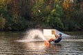 An athlete performs a trick on the water. Park at sunset. Wakeboard rider Royalty Free Stock Photo