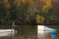 An athlete performs a trick on the water. Park at sunset. Wakeboard rider Royalty Free Stock Photo