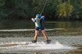 An athlete performs a trick on the water. Park at sunset. Wakeboard rider