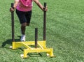 Athlete in pink shirt pushing a sled on turf Royalty Free Stock Photo