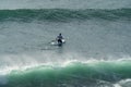 Athlete rides along emerald wave of Black Sea covers the athlete on SUP-board Stand up paddle board.