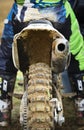 Athlete riding a sports motorbike and muddy wheel on a motocross racing event