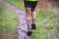 Athlete runner in forest trail in rain, with muddy legs Royalty Free Stock Photo