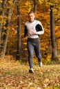 Athlete running in the forest in autumn