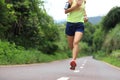 Athlete running on forest trail. woman fitness jogging workout wellness concept.