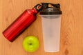 Athlete`s green apple, bottle of water and a red thermocafe on wooden background Royalty Free Stock Photo