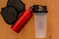 Athlete`s set with female clothing, bottle of water and a red thermocafe on wooden background Royalty Free Stock Photo