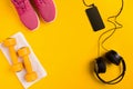 Athlete`s set with female clothing, dumbbells and bottle of water on yellow background Royalty Free Stock Photo