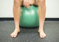 Athlete sitting on a green exercise ball taking a break between her exercises