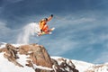 An athlete skier is jumping from high rock high in the mountains.