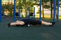 Athlete stretches his back with a massage roller on a street sports ground