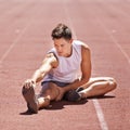 Athlete, stretching and man outdoor for exercise, running or workout at sports stadium. Male runner or sport person on Royalty Free Stock Photo
