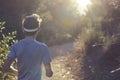 athlete in a sweatband jogging on a sunlit trail