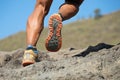 Athlete trail running in the mountains on rocky terrain