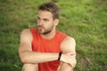 Athlete wear pedometer bracelet on hand. Athletic man relax on green grass. Checking workout results. Technologies make Royalty Free Stock Photo