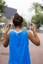 Athlete woman down to headphones before exercising, outdoor.