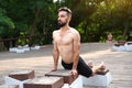 Athlete yogi man practicing yoga in a city park