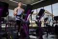 Athlete young man in sportswear doing fitness exercises on xercising on the xtrainer machines in the gym. Healthy lifestyle