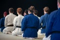 Athletes of Karate black belt kneeling in Seiza position, from behind