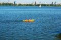 Athletes in kayaks in training near the river fountain in a rainbow of splashes