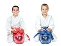 Athletes in kimono sitting in a ritual pose karate with helmets isolated