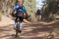 Athletes mountain biking on forest trail