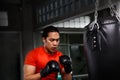 Athletes are punching in the gym. Male action of a boxing fighter training on a punching bag in the gym. Man boxer training is ex Royalty Free Stock Photo