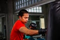 Athletes are punching in the gym. Male action of a boxing fighter training on a punching bag in the gym. Man boxer training is Royalty Free Stock Photo