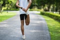 Athletes sport man runner wearing white sportswear to stretching foot and legs and warm up before practicing on a running track at Royalty Free Stock Photo