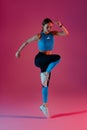Athletic active fitness woman jumping on studio background . Dynamic movement