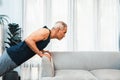 Athletic and active senior man using furniture for pushup. Clout