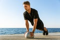 athletic adult man doing push ups with fit ball